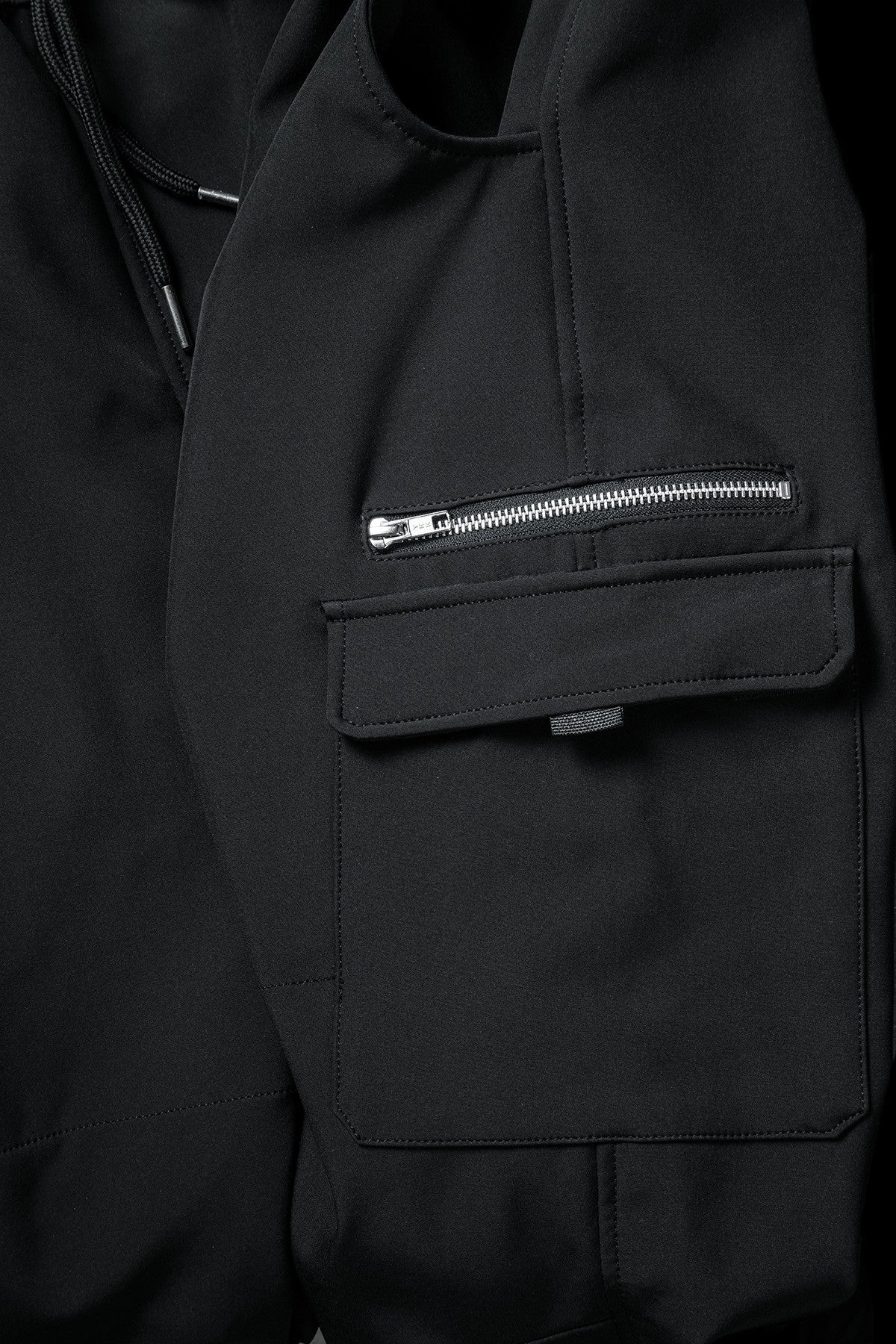 Närbild på fickdetaljer av Sweep Softshell Mc-Byxor College Svart med dragkedja och ficklock. Hållbart softshell-material för motorcykelåkning.